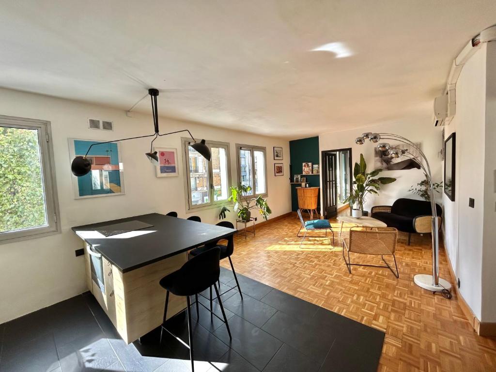 cocina y sala de estar con mesa y sillas en Superbe appartement au porte de Paris et du salon des expositions, en Vanves