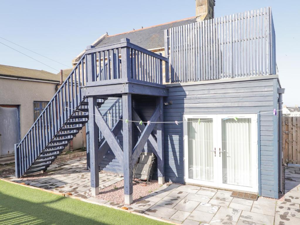 ein blaues Haus mit einer Treppe davor in der Unterkunft Seaview at The Doocot in Elgin