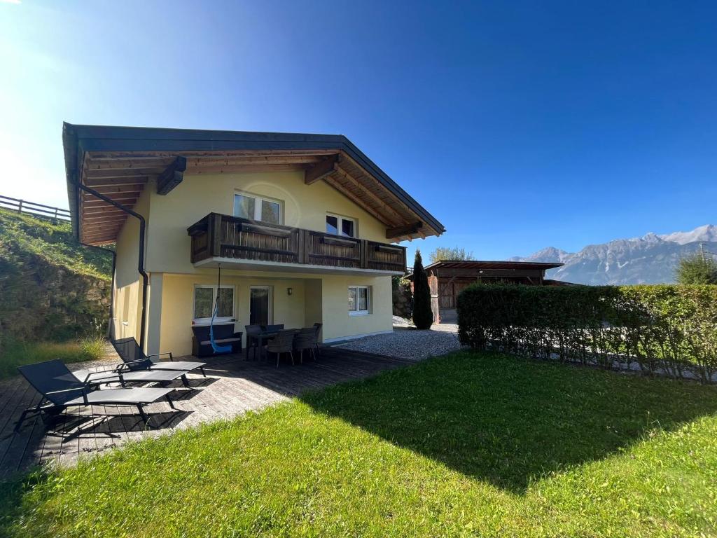 een huis met een balkon en een tafel en stoelen bij Naturerlebnis am Glungezer-Haus-8 Pax in Tulfes