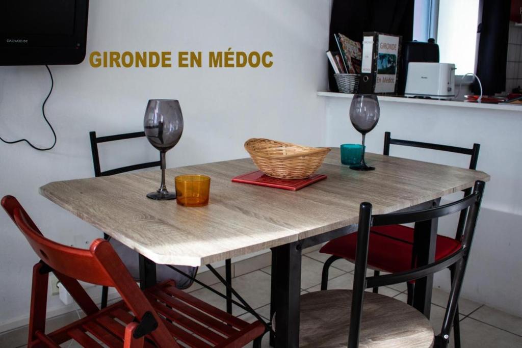 stół z dwoma kieliszkami wina i koszem na nim w obiekcie Bureau Lesparre-médoc, Les Pins w mieście Lesparre-Médoc