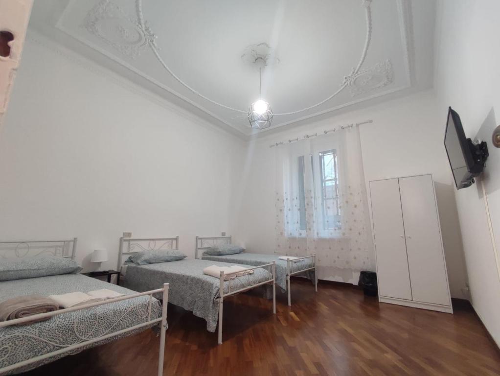a white room with two beds and a table at Lucia appartamento uso esclusivo - Aeroporto Genova Sestri Ponente in Genoa