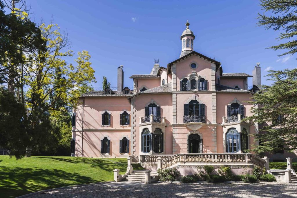 a large pink house with a tower on top of it at Torre del Remei in Bolvir