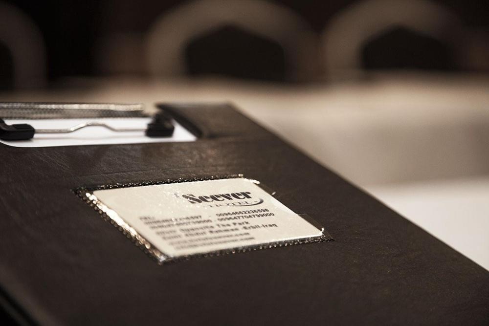 une table noire avec une paire de lunettes dans l'établissement Hotel Seever, à Erbil