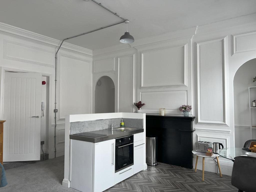 a white kitchen with a sink and a stove at Apartment 10, Plants Yard, Bridge Street. in Worksop