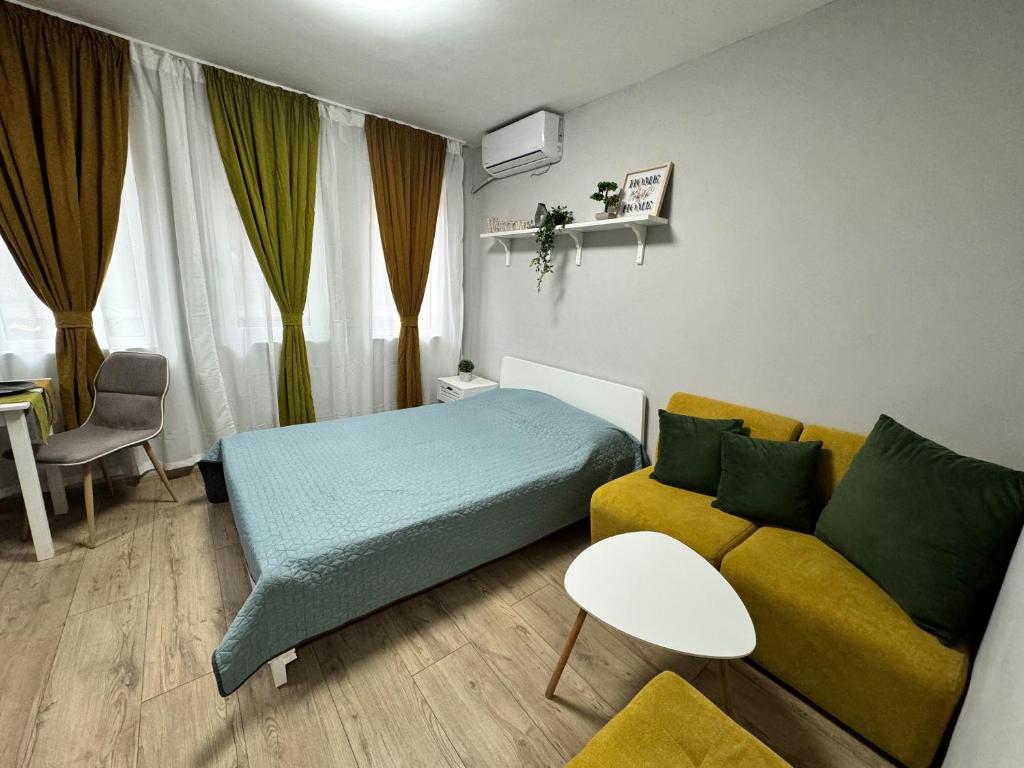 ein kleines Zimmer mit einem Bett und einem Sofa in der Unterkunft Central Studio Apartment - Varna City in Warna