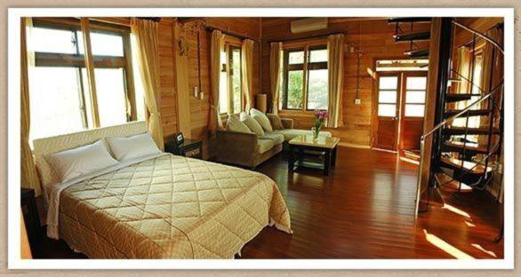a bedroom with a bed and a living room at Summer Trail B&amp;B in Guangfu