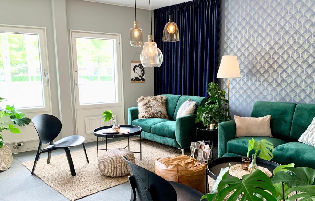 a living room with a green couch and chairs at Linnéplatsens Hotell & Vandrarhem in Gothenburg