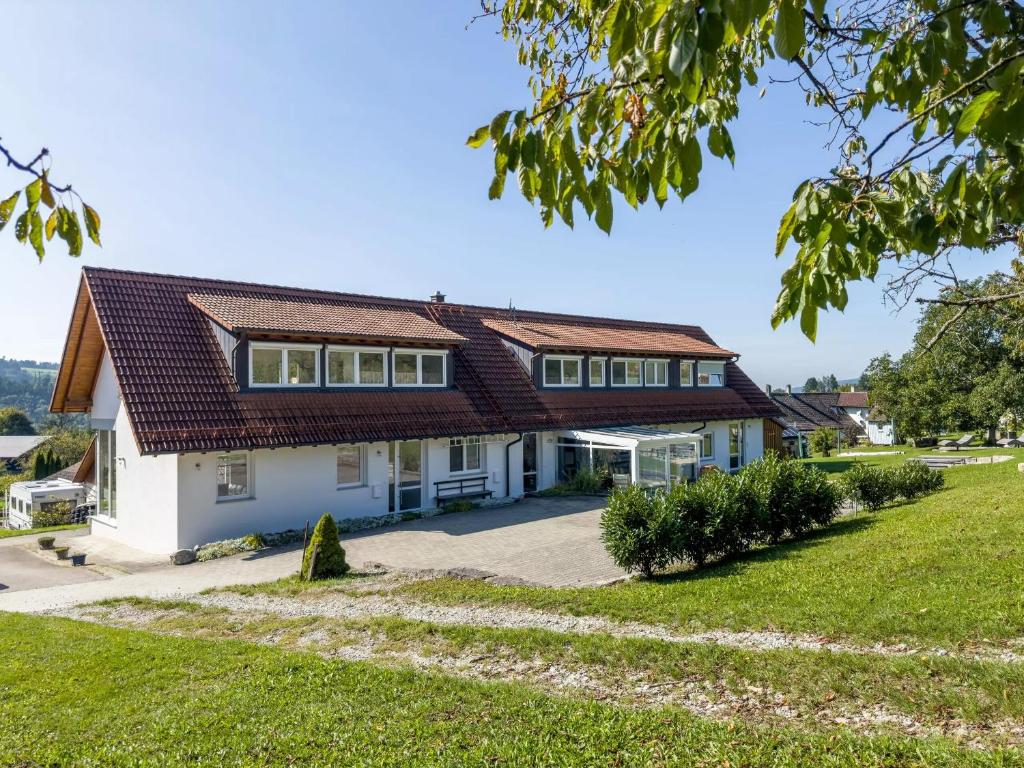 une maison blanche avec un toit marron dans l'établissement Ferienwohnung Buchmann, à Deggenhausertal