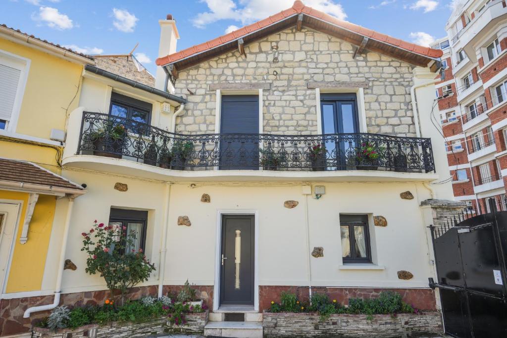 een groot wit huis met een balkon bij Maison moderne parisienne in Colombes