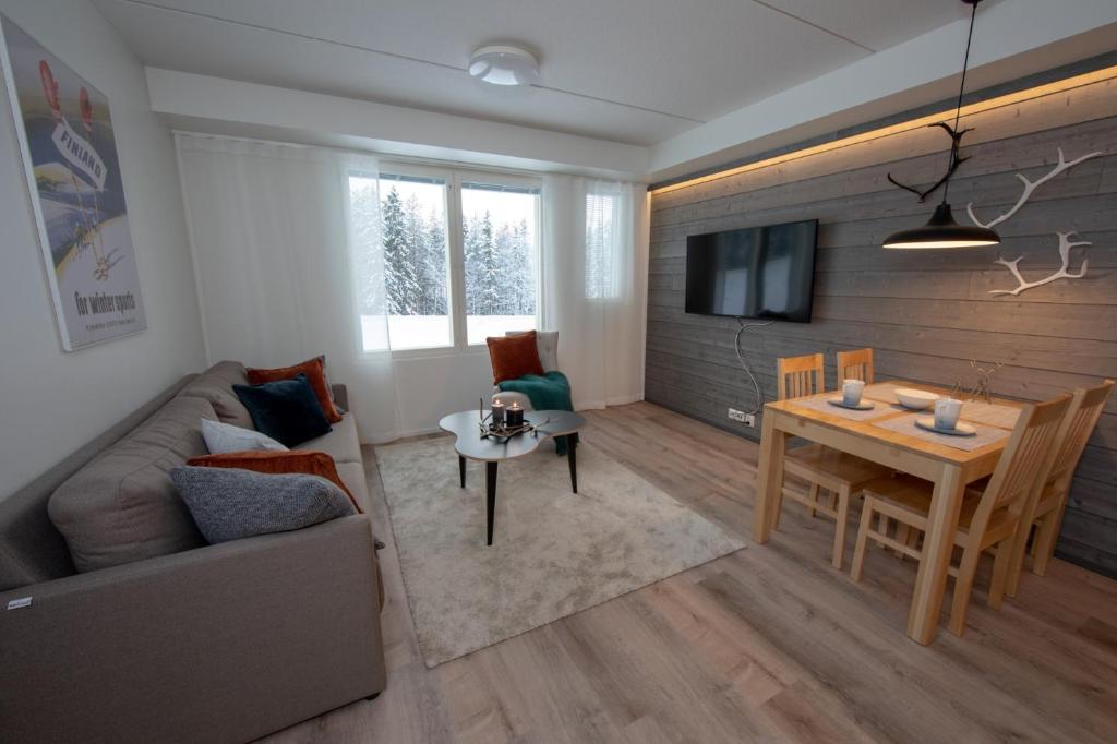 a living room with a couch and a table at Levillenet Suites in Levi