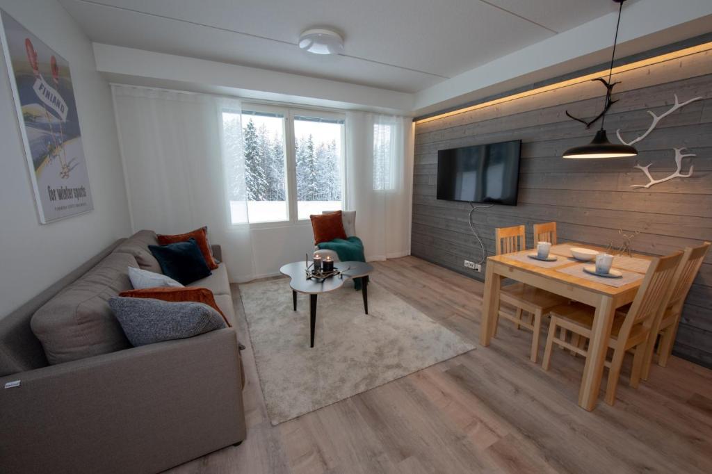 a living room with a couch and a table at Levillenet Skistar Superior apartments in Levi