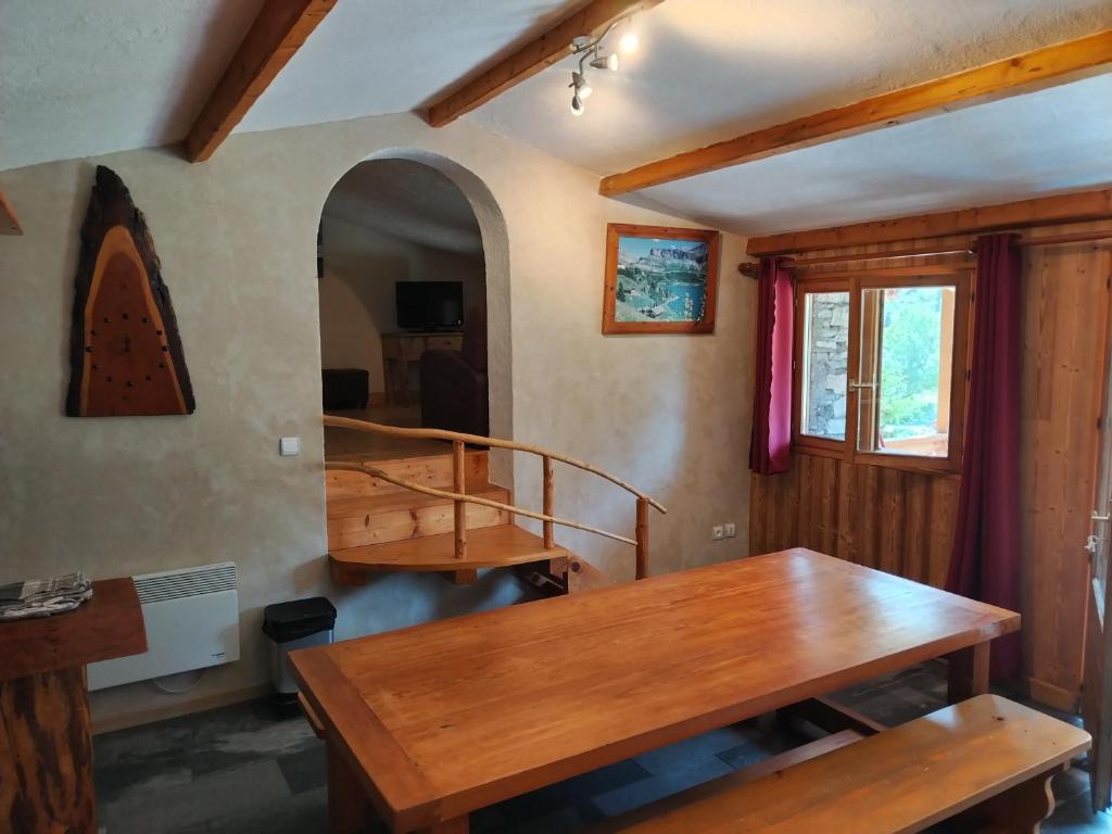 una sala da pranzo con tavolo in legno e scala di Chalet Le Grand Méan a Bonneval-sur-Arc