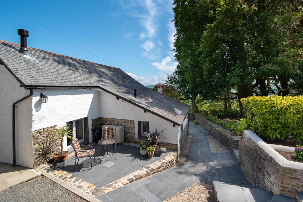 a small white cottage with a patio in front of it at Courtyard Cottage in Barnstaple