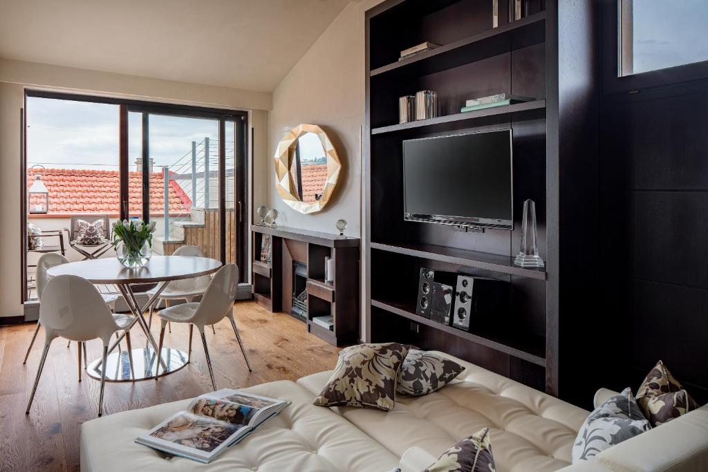 - un salon avec un canapé, une télévision et une table dans l'établissement Repubblica Firenze Luxury Apartments | UNA Esperienze, à Florence