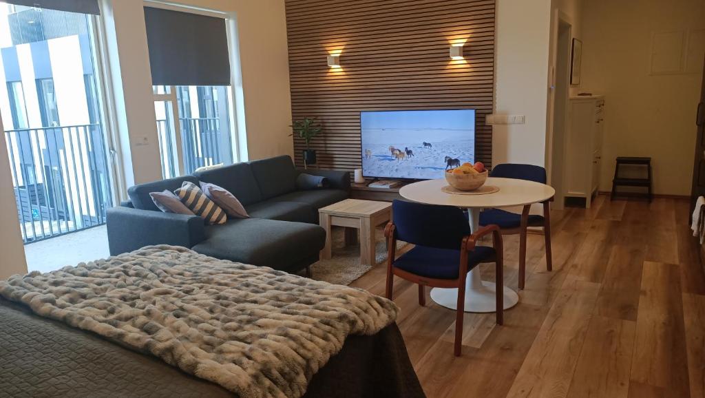 a living room with a couch and a table at Ocean View Suite near Sky Lagoon in Reykjavík