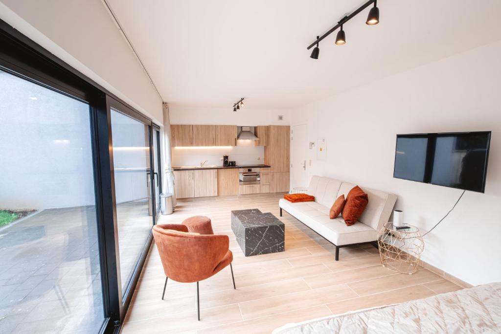 a living room with a couch and a tv at K&Y suites 3, 500m to Brussels airport in Zaventem