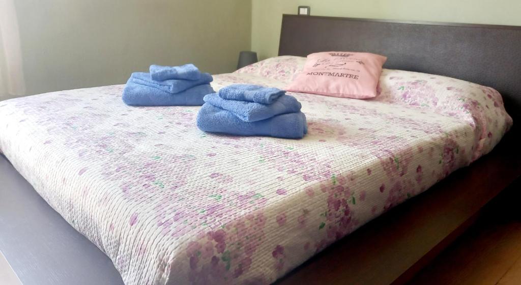 dos toallas azules sentadas encima de una cama en La Casa di Barbanella, en Grosseto