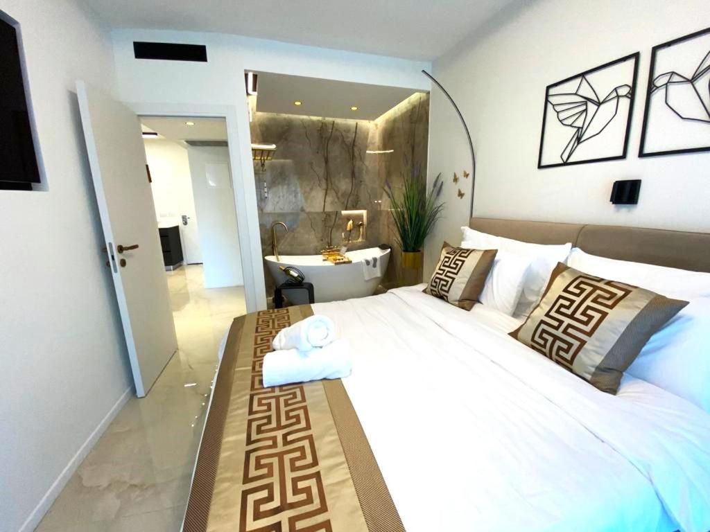 a bedroom with a large white bed and a bathroom at Rose Suite in Caesarea