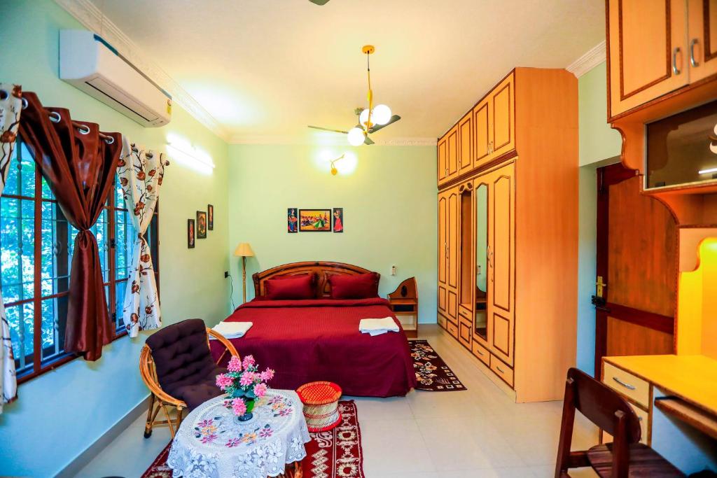 a bedroom with a red bed and a table at Bay Homes 2BHK WT Bathtub Near Rock Beach in Puducherry