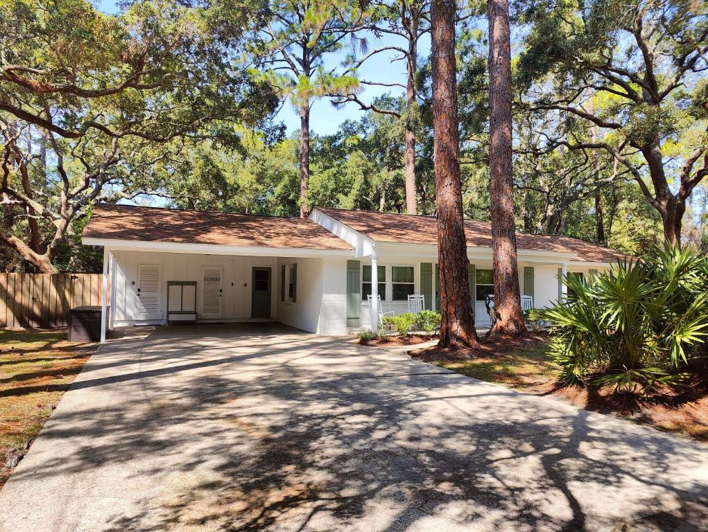 a white house with trees in front of it at Jekyll Island House/ Kellys On The Coast /King bed in Jekyll Island