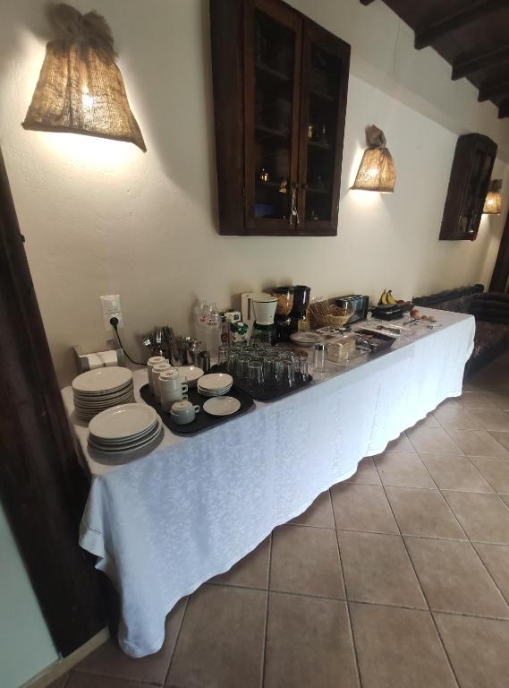 einen Tisch mit Tellern und Geschirr in der Küche in der Unterkunft Allotino Hotel - Café & snacks in Stavrodhrómion