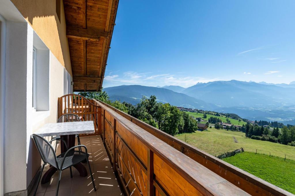 a balcony with a table and chairs and mountains at Apt Waldblick in Maranza