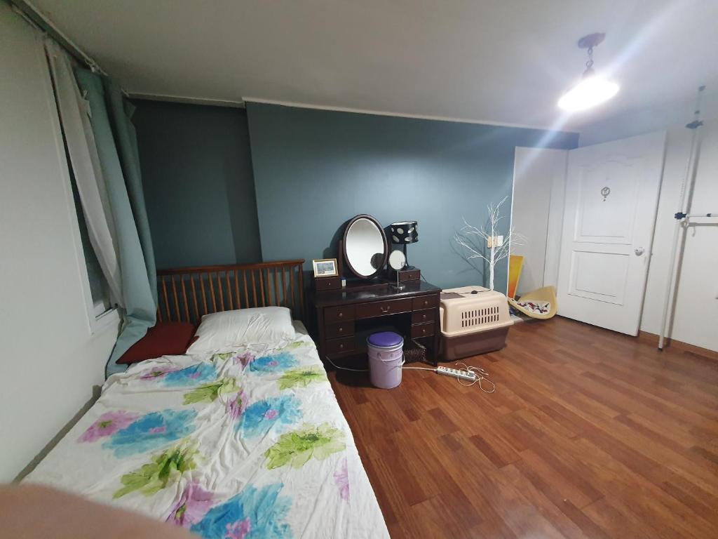 a bedroom with a bed and a dresser and a mirror at Heukseok Town House in Seoul