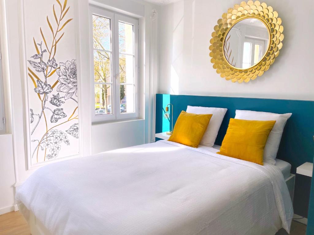 1 dormitorio azul y blanco con 1 cama con almohadas amarillas en L'intemporel - Grand T2 climatisé & terrasse, en Castres