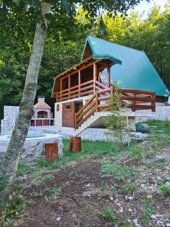 a log cabin with a blue roof and a house at Eko katun Mirac in Danilovgrad