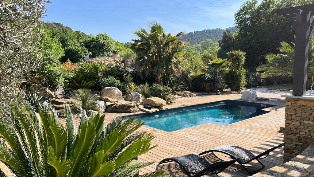 une cour arrière avec une piscine et deux chaises dans l'établissement Villa Palmera, à Saint-Cyr-sur-Mer