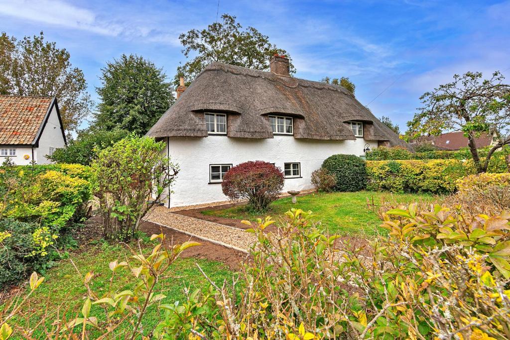 an old white house with a thatched roof at Finest Retreats - Chocolate Box Cottage in Potton