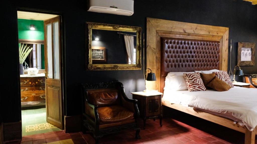 een slaapkamer met een bed, een stoel en een spiegel bij Estancia Don Joaquín Argentina in Esquina