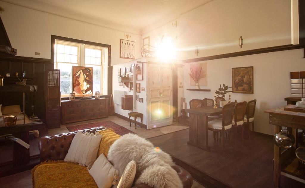 a living room with a couch and a table at Spacious & Light Studio Loft in Alloa