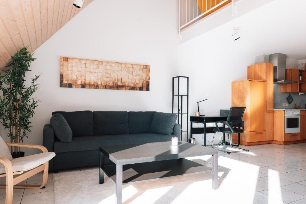 a living room with a couch and a table at Maisonette-Wohnung Airport/Messe Stuttgart - Balkon - Parkplatz - Netflix in Filderstadt