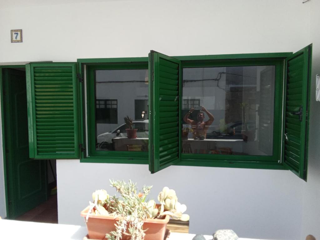 two green shutters on a wall with a sink at Famarabeach in Famara