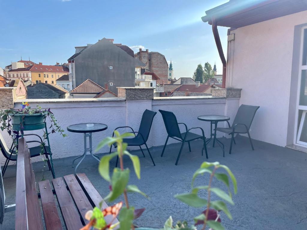 a patio with chairs and tables on a balcony at Boutique Apartments Oradea in Oradea