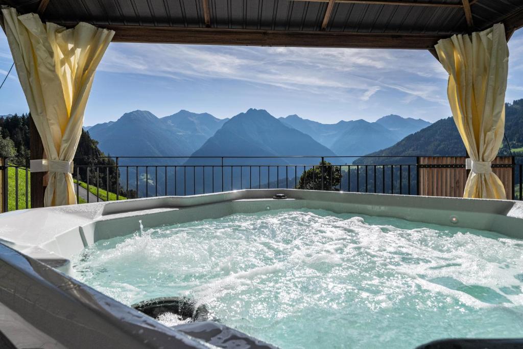 een hot tub met uitzicht op de bergen bij Sunnseitn Lodge Exclusive Panorama in Stulles
