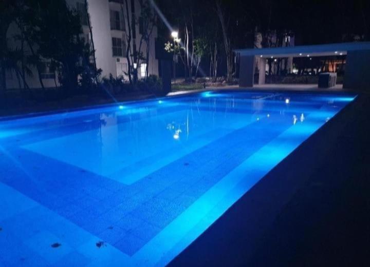 - une grande piscine avec des lumières bleues la nuit dans l'établissement Playa del Carmen kassita Bambu, à Playa del Carmen