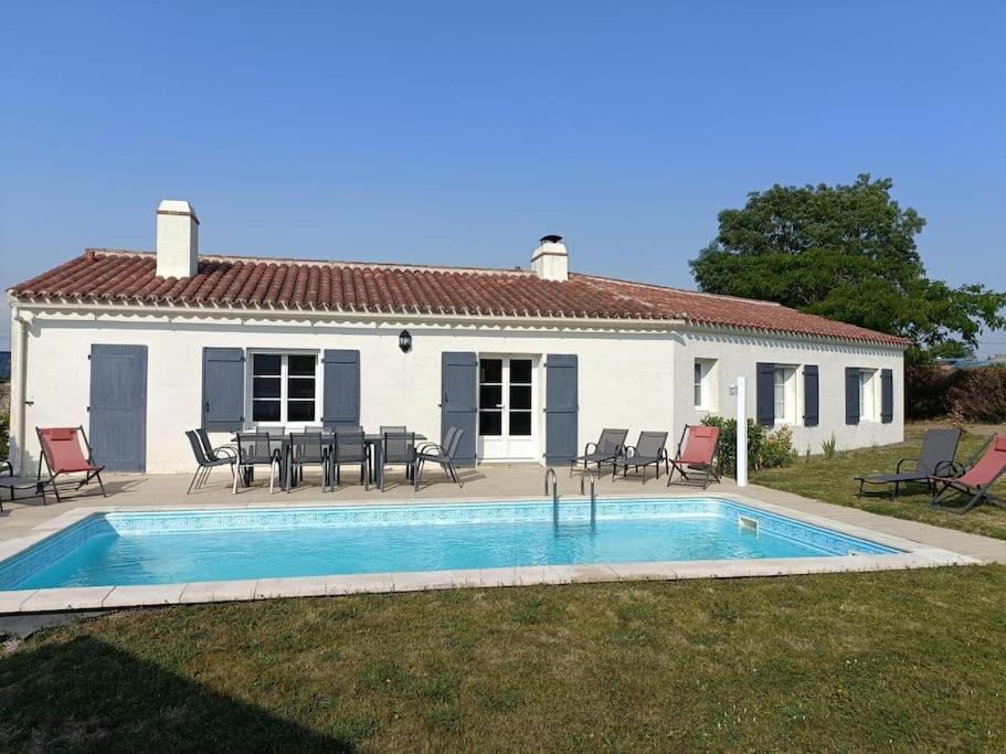 una casa con piscina frente a ella en Les Bruyères Maison au calme avec piscine chauffée, en Chantonnay