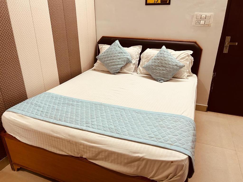 een bed met blauwe en witte kussens erop bij The For You Hotel & Restaurant in Rishīkesh