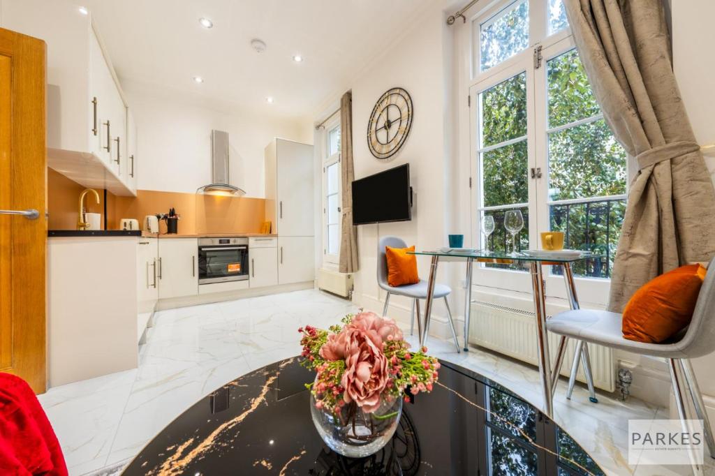 a kitchen with a glass table with a vase of flowers at The Signature Residences in London