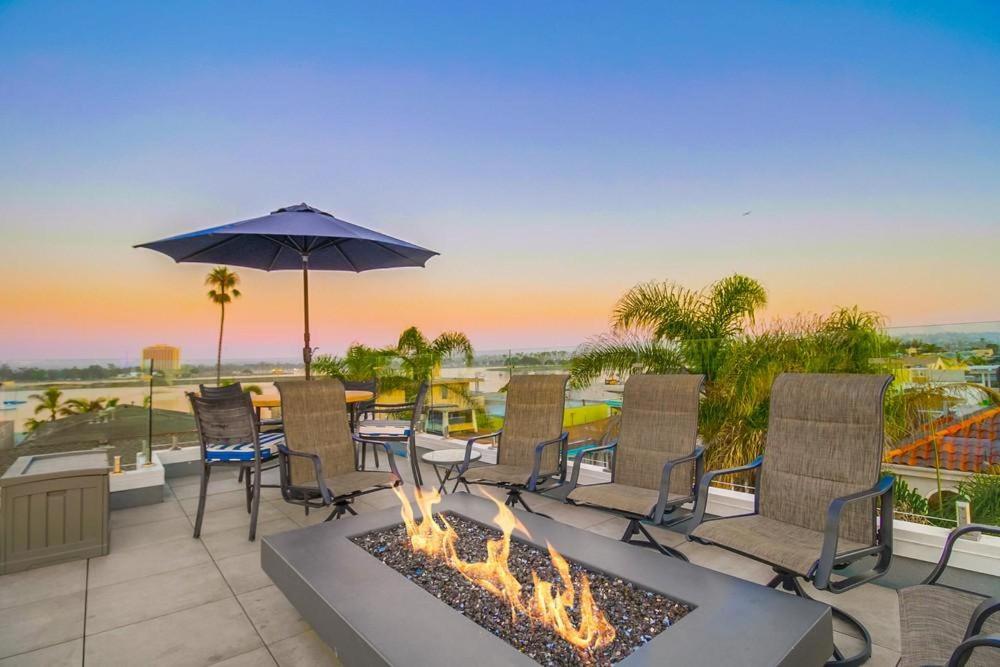 a fire pit on a patio with chairs and an umbrella at Beach Haven 2 in San Diego