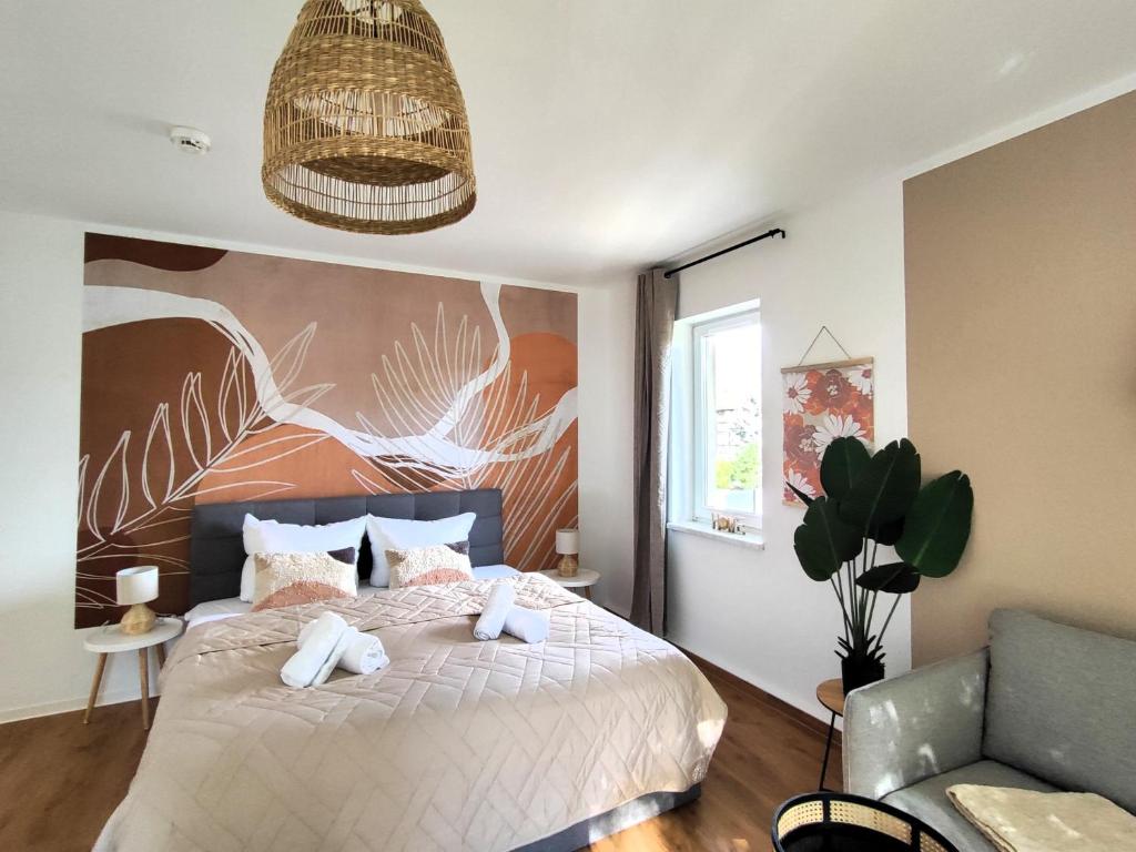 um quarto com uma cama com uma grande pintura na parede em BohnApartments Bechstein - Kreuz Erfurt - 2x Smart-TV-Balkon- gratis Stellplätze- WLAN - Vollausstattung - sehr ruhig em Neudietendorf