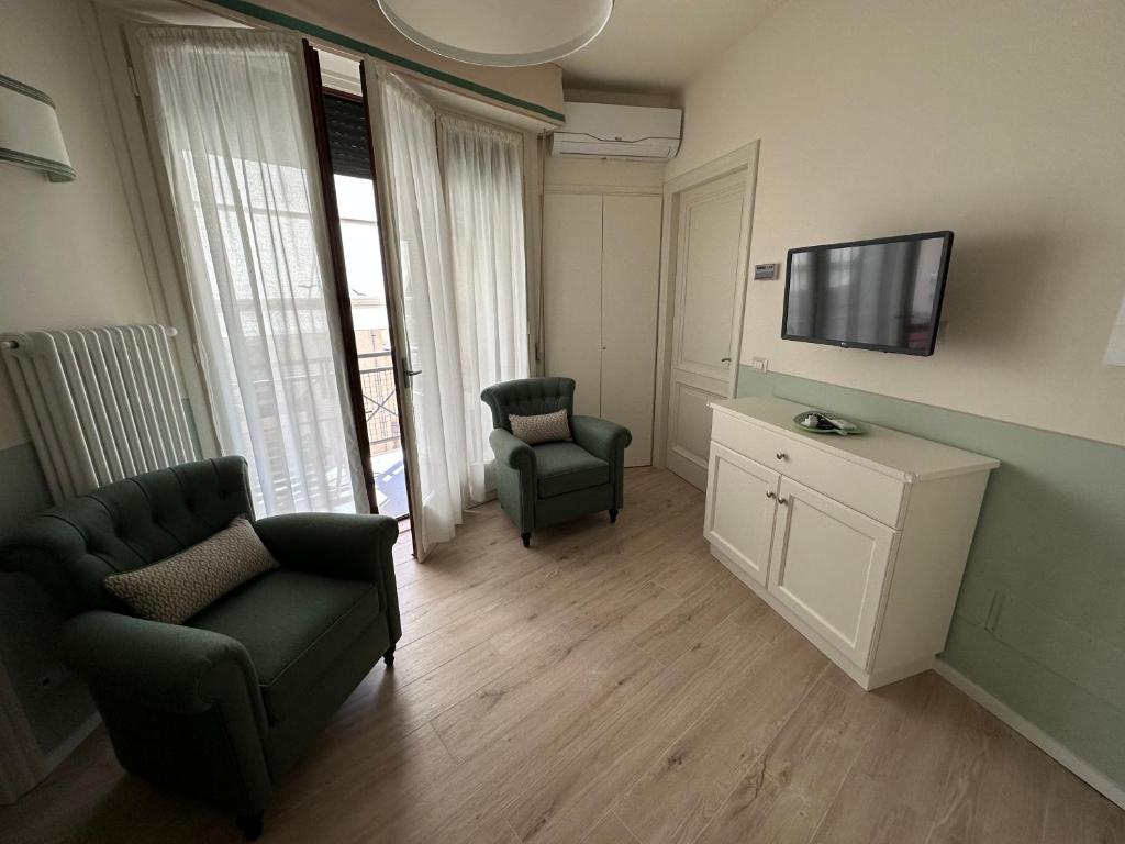 a living room with a couch and a tv and chairs at San Gimignano, Siena La casina di Zigino in San Gimignano