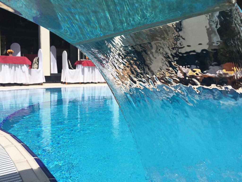a swimming pool with a fountain in a hotel at Apartment Eney in Lviv