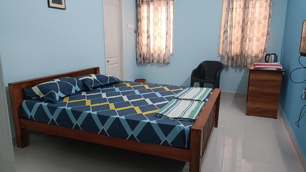um quarto com uma cama azul e amarela em Shantham Service Apartments, Indumanagar, Coimbatore em Coimbatore