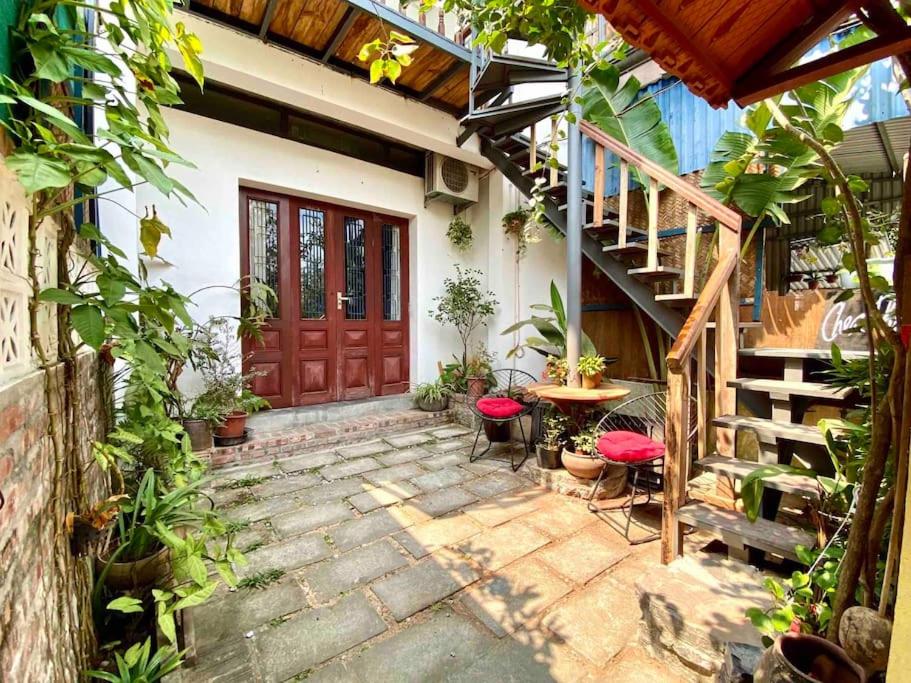 a patio with a wooden door and a table and stairs at Chez Phuong Cat Ba -Private entire house in Cat Ba