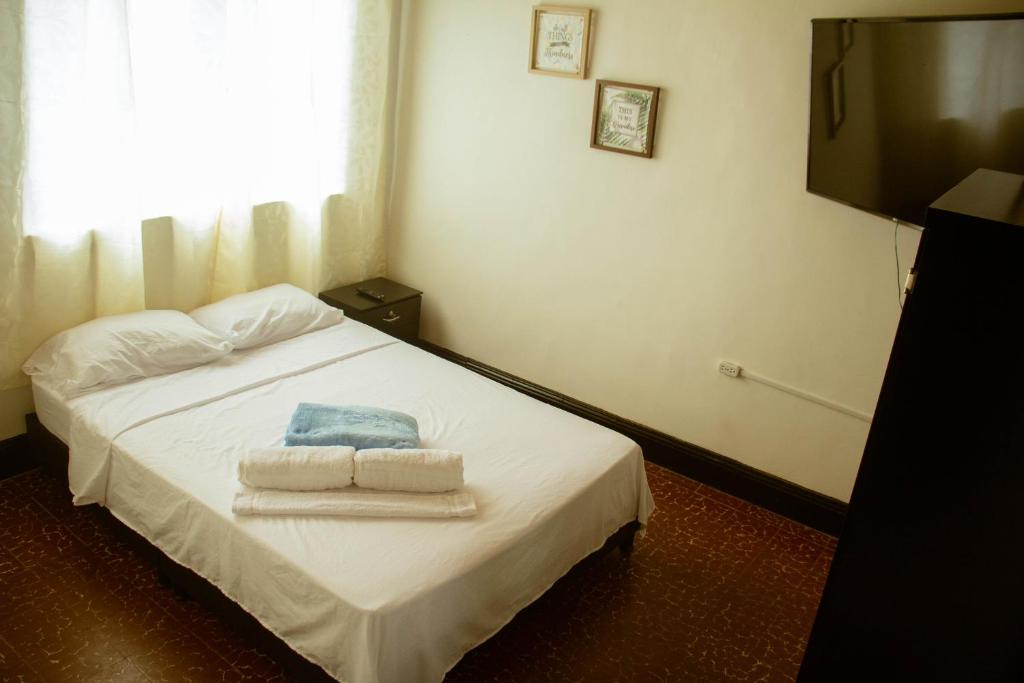 sypialnia z łóżkiem z ręcznikami w obiekcie Coliving La Rebeca Pereira w mieście Pereira