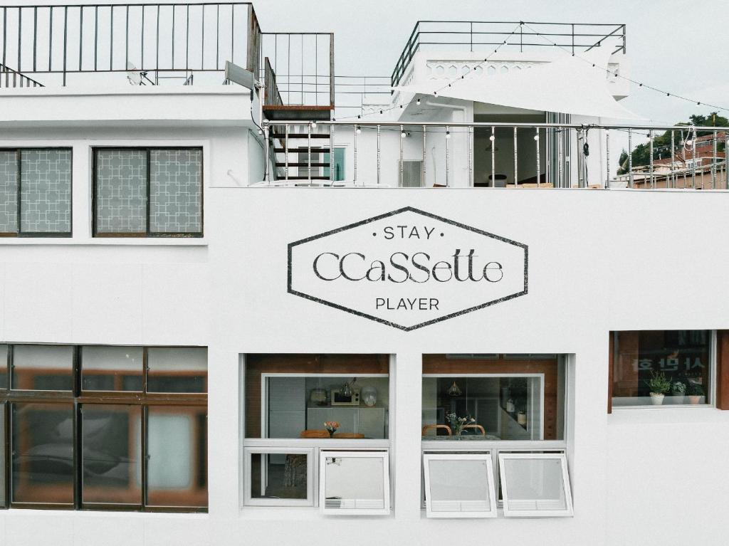 un edificio bianco con un cartello che dice "giocatore di casseruola di permanenza" di Stay Ccassette Player a Mokpo