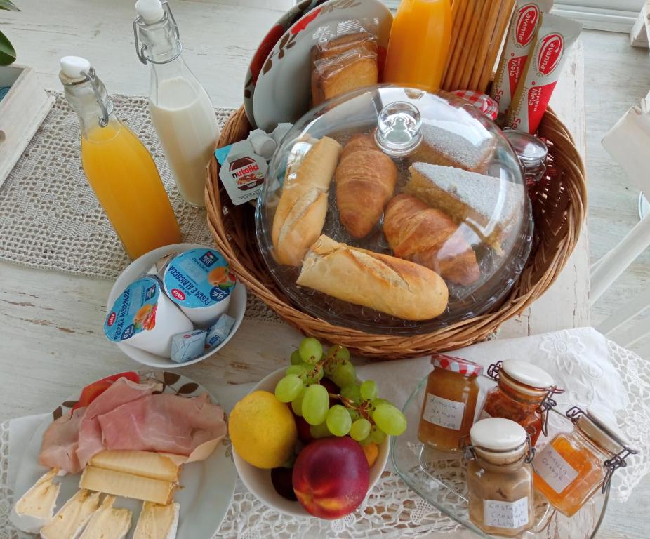 a table topped with a basket of bread and fruit at Message in a Bottle Bed and Breakfast in Camporosso